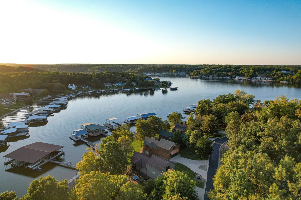 A serene view across the lake, with docks, houses, and lush trees. The peaceful water and scenic natural surroundings evoke the idea of local exploration, boating, and connecting with the outdoors—all elements that reinforce the 'explore' and personalized guide themes from the section.